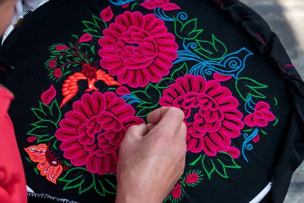 Woman embroidering some flowers