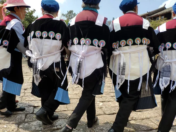 16 Mart 2019: Sokakta geleneksel Naxi etnik grubu kostümüyle dans eden kadınlar. Lijiang, Çin