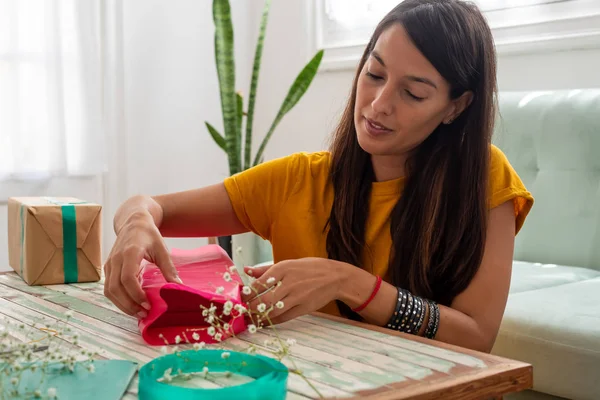 Kobieta pakowanie ręcznie robione prezenty rzemieślnicze na stole w domu — Zdjęcie stockowe