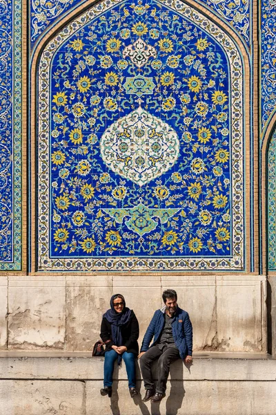 March 2, 2019: Couple seated in front of a blue mosaic. Isfahan, Iran — Stock Photo, Image