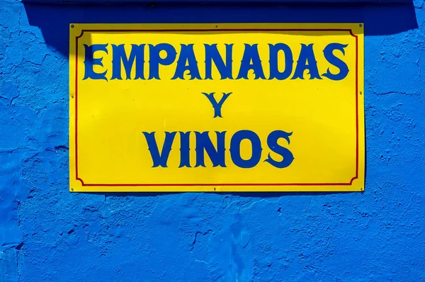 アルゼンチンのブエノスアイレスにある「パスティーとワイン」の印のある黄色と青の壁 — ストック写真