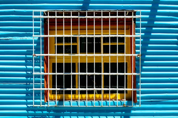 Blue and yellow metal window of a facade in Caminito street in Buenos Aires