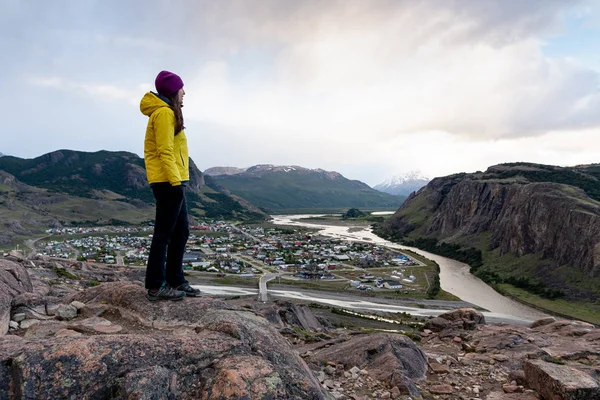 Caminante solo con chaqueta amarilla admirando las vistas sobre el pueblo de El Chalten. Patagonia, Argentina — Foto de Stock