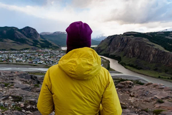 Caminante solo con chaqueta amarilla admirando las vistas sobre el pueblo de El Chalten. Patagonia, Argentina —  Fotos de Stock