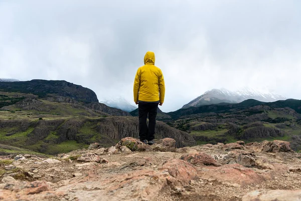 Egyedül egy sárga kabátos túrázó, aki az Andokra néz. Patagónia, Argentína — Stock Fotó