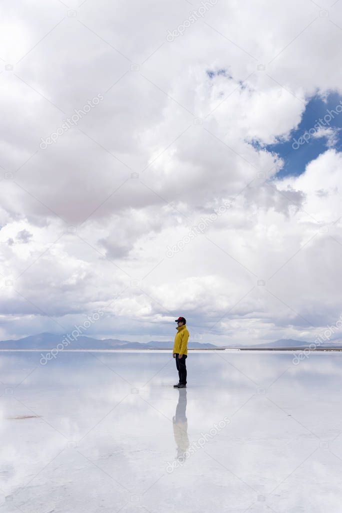 Reflection of a Lone Man walking on a salt flat in Salta, Argentina