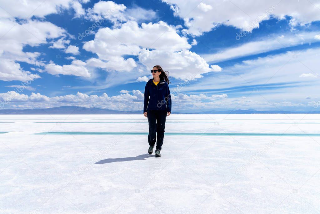 A young tourist woman walking on a salt flat in Salta, Argentina  