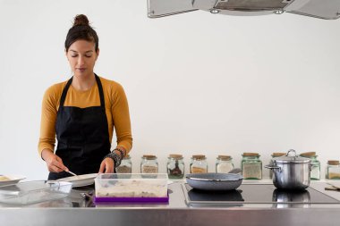 Esmer kadın modern bir mutfakta ev yapımı kroket pişiriyor.