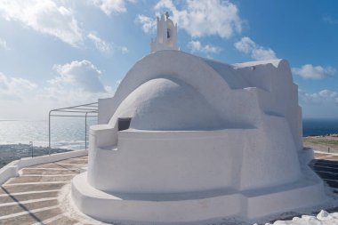 Yunanistan 'ın Santorini adasında denizin önündeki Ortodoks beyaz kilisesi