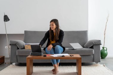 Genç bir kadın evinde çalışıyor ve iş görüşmesi yapıyor.