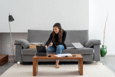 Genç bir kadın evinde çalışıyor ve iş görüşmesi yapıyor.