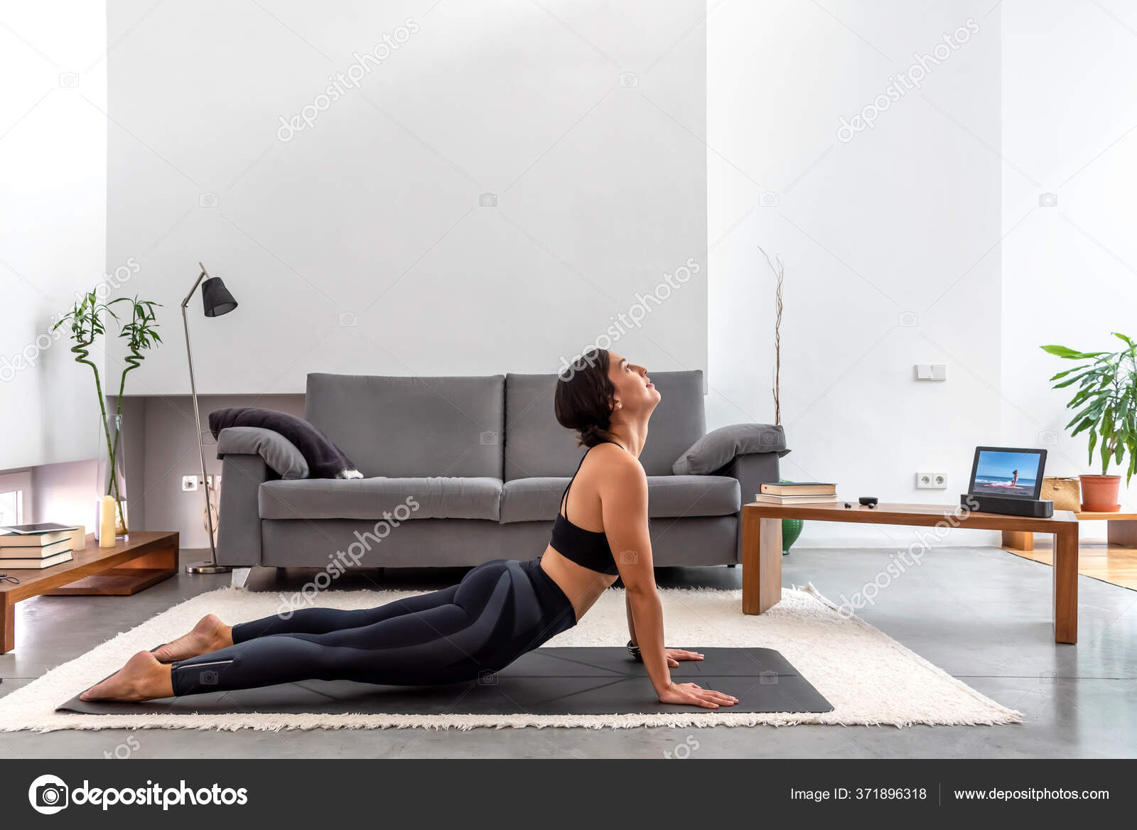 Fit Woman Practicing Cobra Pose Using Online Yoga Training Program Stock Photo by ©BisualPhoto 371896318