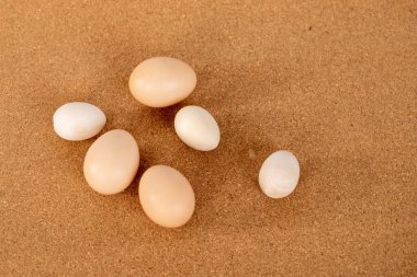 Farklı boyutlarda yumurtalar masaya saçılmış..