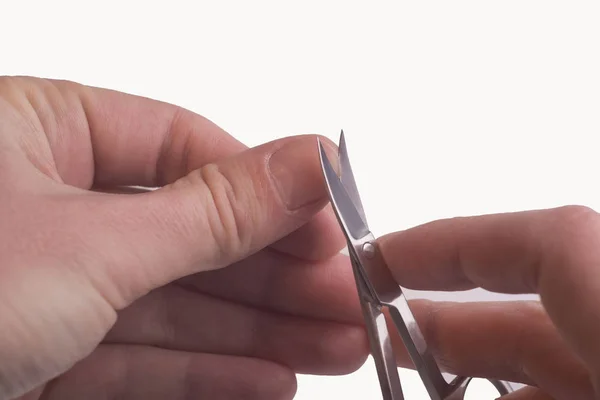 Primo piano di una mano di un uomo che si taglia le unghie. Isolato su sfondo bianco — Foto Stock