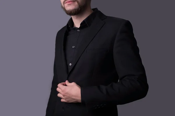Um homem de casaco preto, com um fundo cinzento escuro. conceito minimalista. Espaço vazio. — Fotografia de Stock