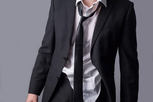 Portrait d'un homme d'affaires, en costume d'affaires désordonné, vêtements ridés, look bâclé. Sur un fond gris — Photo