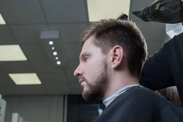 Close-up master hairdresser blow-dry a young guy in barbershop — 스톡 사진