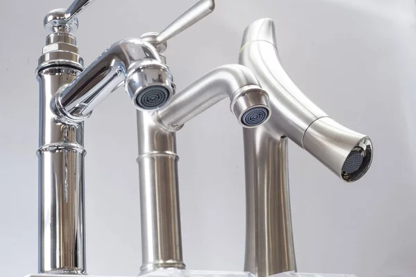 A variety of faucets taps on a white shelf in the store counter — Stock Photo, Image