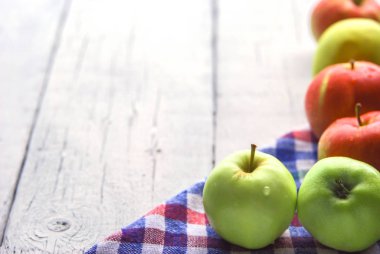 .elma arkaplanı. Beyaz ahşap bir masada. Kırsal bir tarzda. Kitaplar