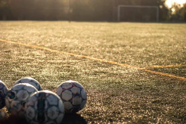 Soccer balls on the field for playing ball. Against the background of the gate Warm tinting Low morning light — Stock Photo, Image
