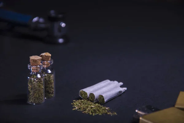 Tıbbi kullanımı olan tıbbi marihuana. Otlu yassı sigara, çakmak, fonendoskop, uyuşturucu şişesi.