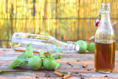 Elma şarabı şişelere döküldü. Elma sirkesiyle dolu bardaklar eski bir şarap masasının üzerinde. Sıcak renklerde. Yaz tatili