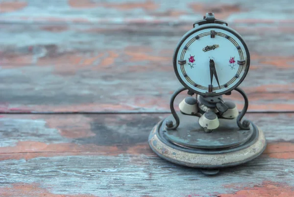 Old retro alarm clock on table with pastel background