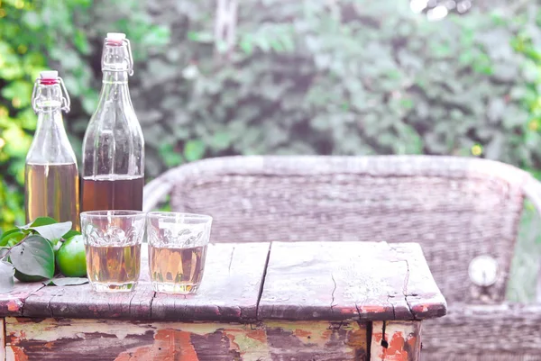Яблучний сидр, пляшка, стоїть на старому дерев'яному столі . — стокове фото