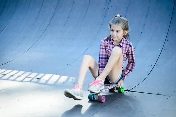 Μικρό κορίτσι skateboard κάθεται σε ένα skateboard — Φωτογραφία Αρχείου