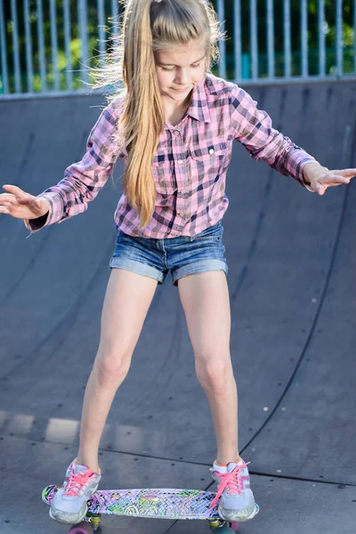 Menina aprende a patinar no skate — Fotografia de Stock