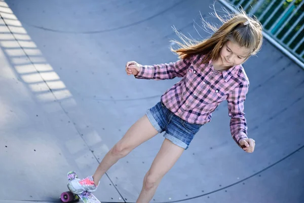 Skater fêmea passeios de skate na rampa do parque de skate. Jovem praticando skate ao ar livre no parque de skate . — Fotografia de Stock