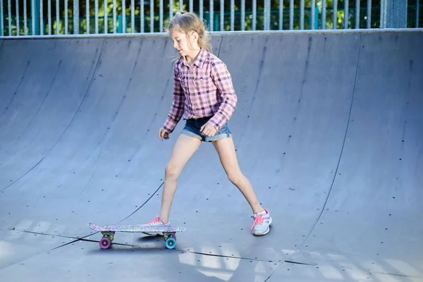 Tonårstjej tränar skateboard, utomhus i skateboard park — Stockfoto