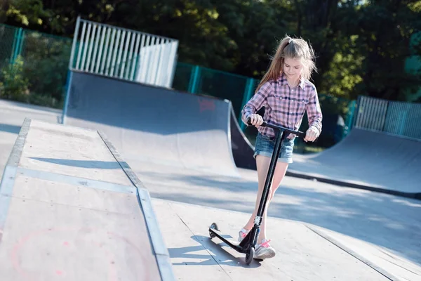 Estilo de vida saudável na infância. Retrato de uma menina pequena e ativa montando uma scooter de atividades esportivas infantis . — Fotografia de Stock