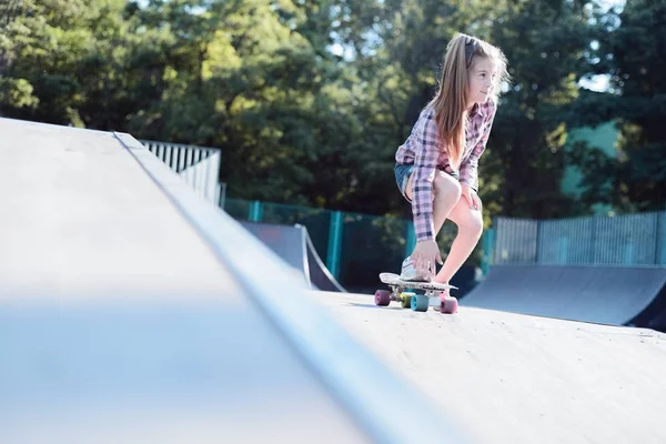 Retrato de uma adolescente ativa, realizando um truque de skate — Fotografia de Stock