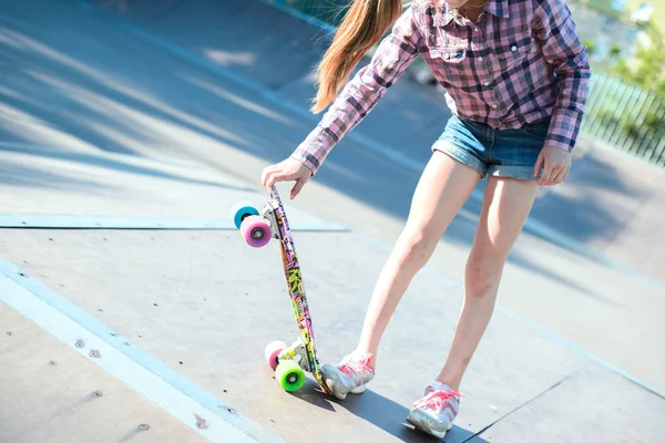 Klein tienermeisje, het doen van een skateboard truc, op een skatepark — Stockfoto