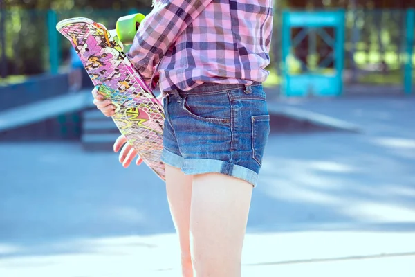 Adolescente, segura em mãos skate, ao ar livre, close-up — Fotografia de Stock