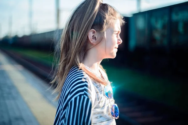 Retrato de uma linda menina esperando por um trem na estação — Fotografia de Stock