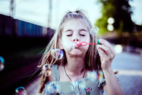 Menina feliz bonito bebê soprando bolhas de sabão — Fotografia de Stock