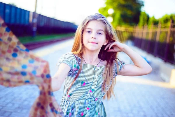 Linda menina adolescente segura um lenço na mão e endireita seu cabelo lindo — Fotografia de Stock