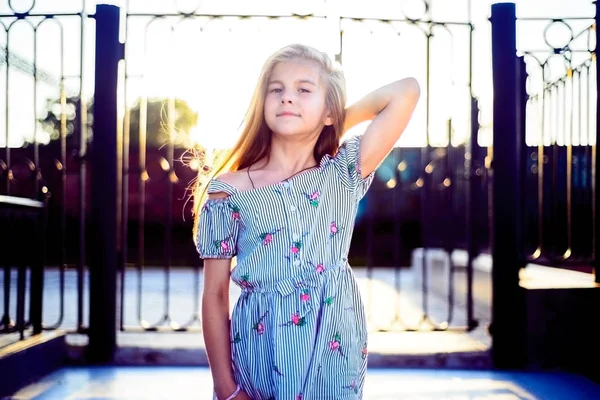 Menina bonita em um vestido de verão demonstra a saúde do cabelo. Estilo de vida das crianças — Fotografia de Stock