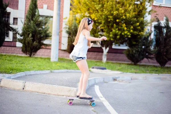 Piccola adolescente cavalcando uno skateboard per strada — Foto Stock