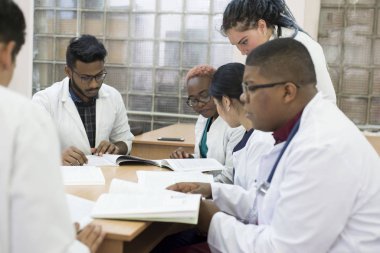Tıp doktoru. Ofiste masa başında oturmuş tıbbi konuları ve konuları tartışan bir grup melez doktor. Tıbbi Konsiyum