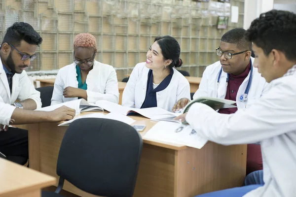 A group of young doctors, mixed race. Sit at the table discussing medical topics. — 스톡 사진