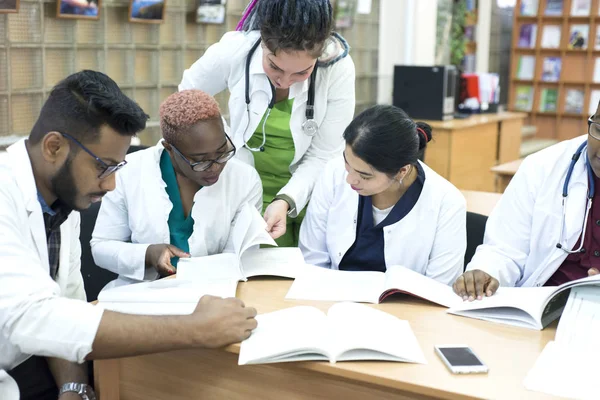 Молоді лікарі Група людей змішаної раси, сидячи за столом, розмовляючи, обговорюючи проблеми зі здоров'ям . — стокове фото