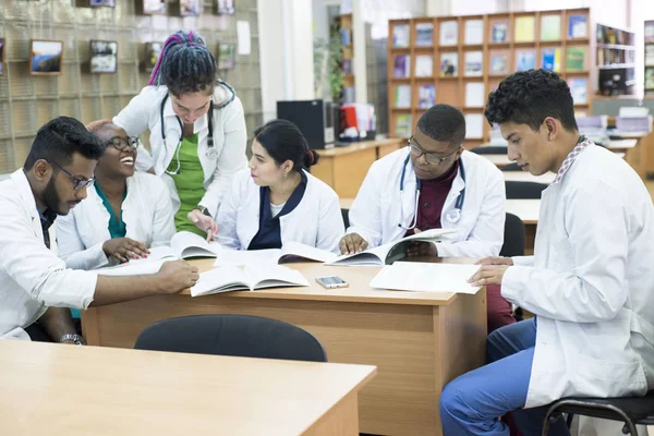 Молоді лікарі Група людей змішаної раси, сидячи за столом, розмовляючи, обговорюючи проблеми зі здоров'ям . — стокове фото