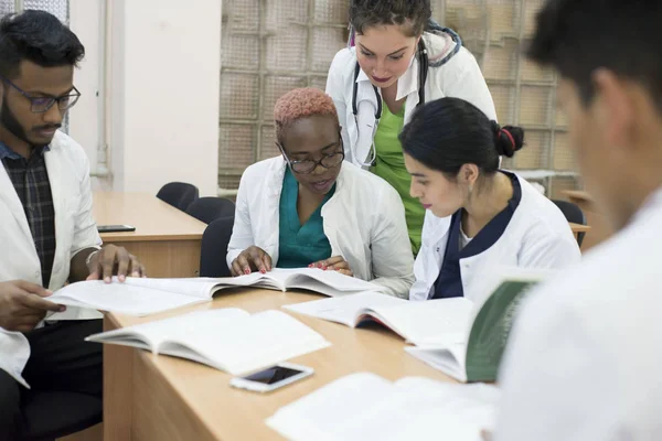 A group of mixed race doctors discussing medicine in the office at the table. — 스톡 사진