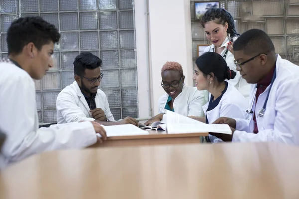 Medisch advies. Een groep van gemengde jonge mannen, zittend aan een tafel in een ziekenhuiskantoor, bespreekt medische onderwerpen. — Stockfoto