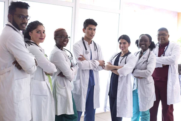 Team of young doctors, mixed race. People of different sex, in white coats, with phonendoscopes, posing, smiling — 스톡 사진