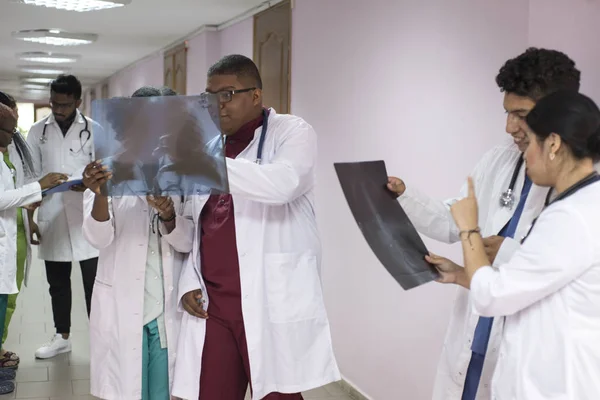 Un grupo de jóvenes médicos de raza mixta de diferente género. Estar en el hospital, mirando la radiografía — Foto de Stock