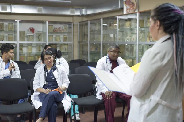 Группа медицинских работников с цифровыми планшетами встречается в зале заседаний больниц. Медицинский персонал во время утреннего брифинга . — стоковое фото